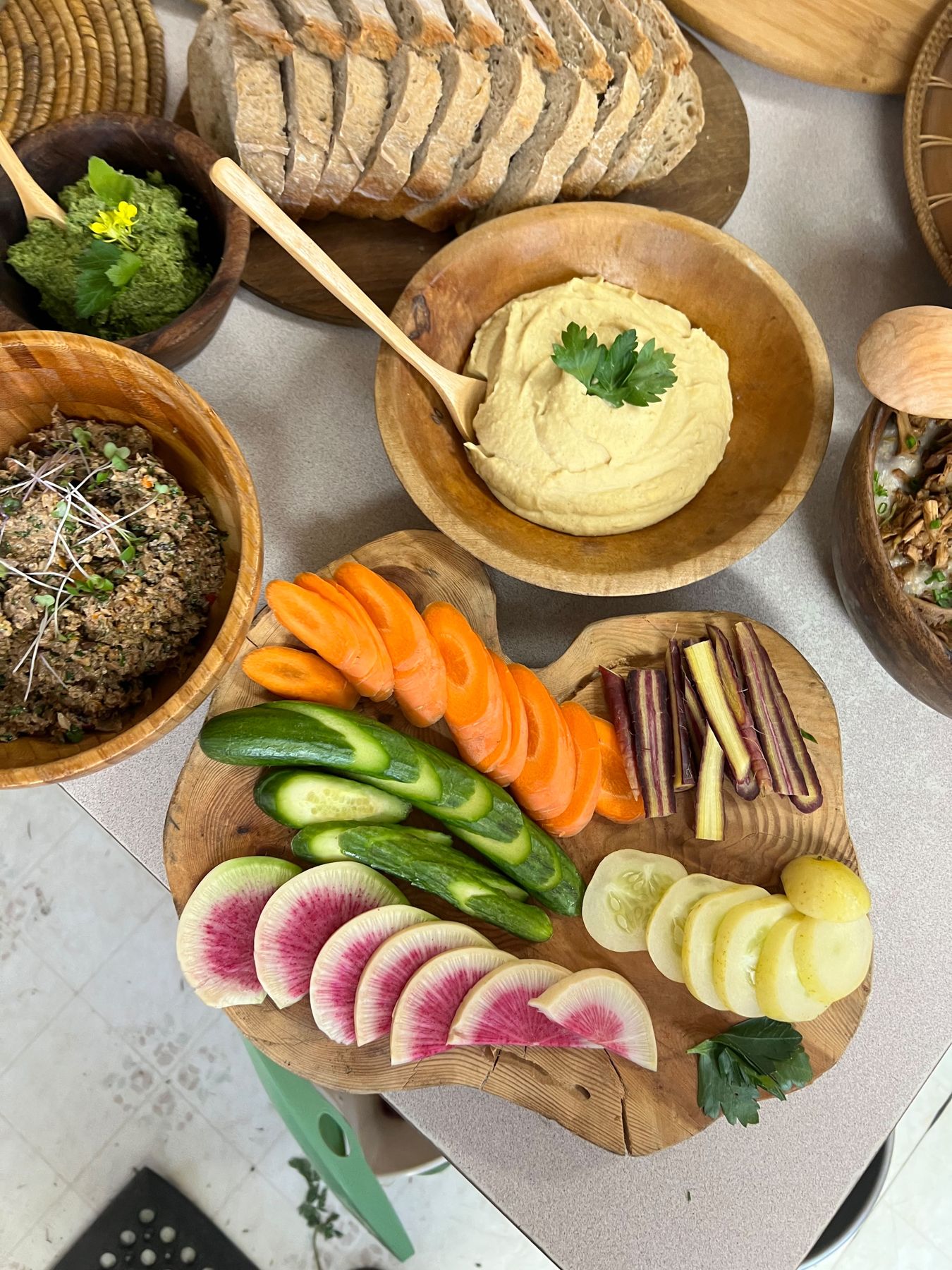 Shared table of fresh bread, dips and vegetables