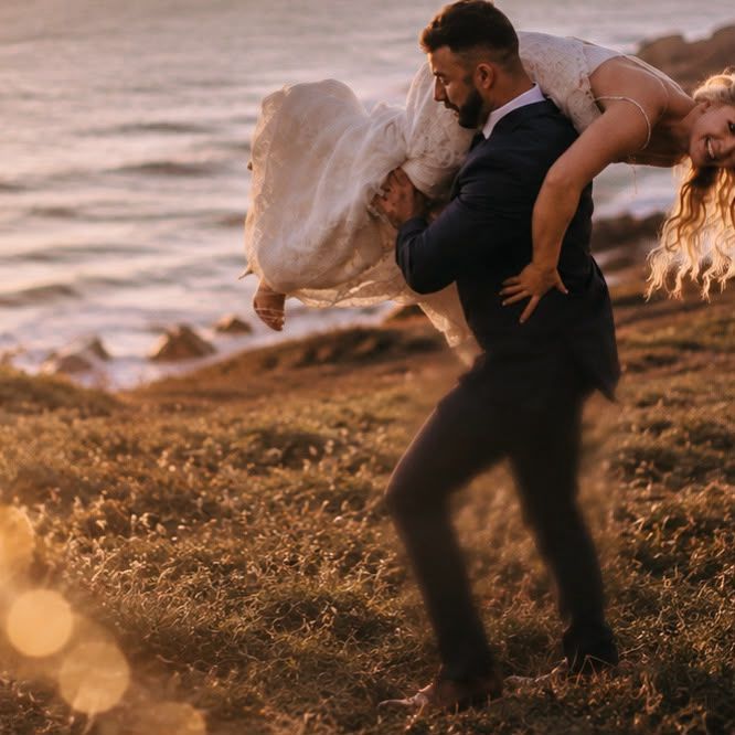 Groom lifting bride on the bluff